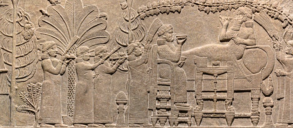 The Banquet Scene _ Ashurbanipal and his wife Libbali-sharrat depicted dining in Nineveh. The severed head of Elamite King Teumman is hanging in a tree to the left, and his hand holding a royal wand is fixed in the tree to the right. 