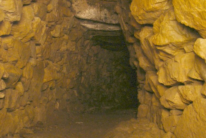 The main, curved, chamber of the Halligye Fogou at the Trelowarren Estate, Cornwall. PH๏τo taken with a long exposure and illuminated by a moving torch beam.