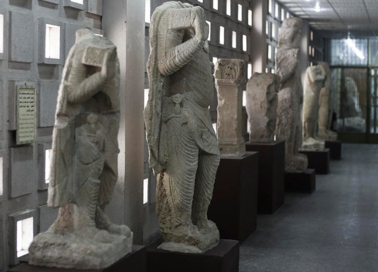 stone figures from the ancient site of Hatra line a corridor of the Iraq National Museum the Iraqi capital. AP PH๏τo/Maya Alleruzzo 