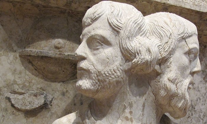 A statue of the Roman god Janus (sense 1) in the collection of the Museum of Ferrara Cathedral in Ferrara, Italy. Janus is traditionally depicted as having two faces, one looking to the past and the other the future.