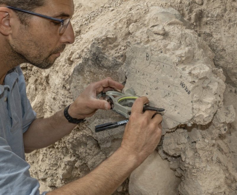 Yoav Vaknin measuring at the site. Credit: Shai Halevi, Israel Antiquities Authority