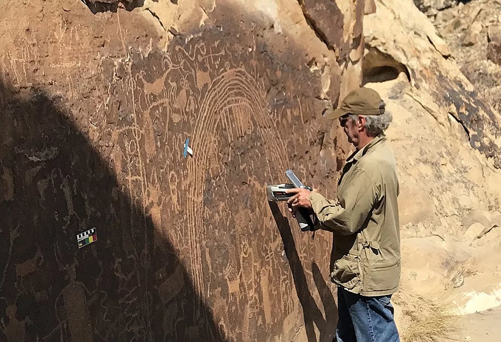 Meinrat O. Andreae takes measurements on the rock varnish using a portable X-ray fluorescence device. © Tracey W. Andreae