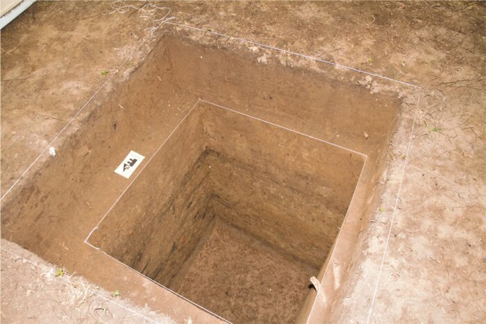 An excavation before sampling. Note the color changes between layers. The darker layers have carbon-rich deposits made by humans, such as midden or garbage that was scraped up and dumped to form the ridge structure during construction. There is little organic garbage in the upper third section. Credit: T.R. Kidder